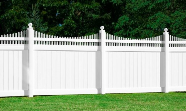 A white picket-style vinyl privacy fence