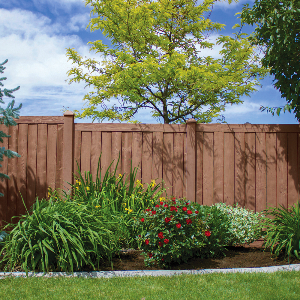 Vinyl fence next to plants and tree