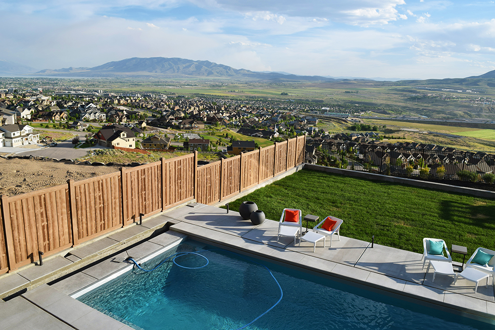 Vinyl wood fence in a yard with a pool overlooking a neighborhood in a mountain valley