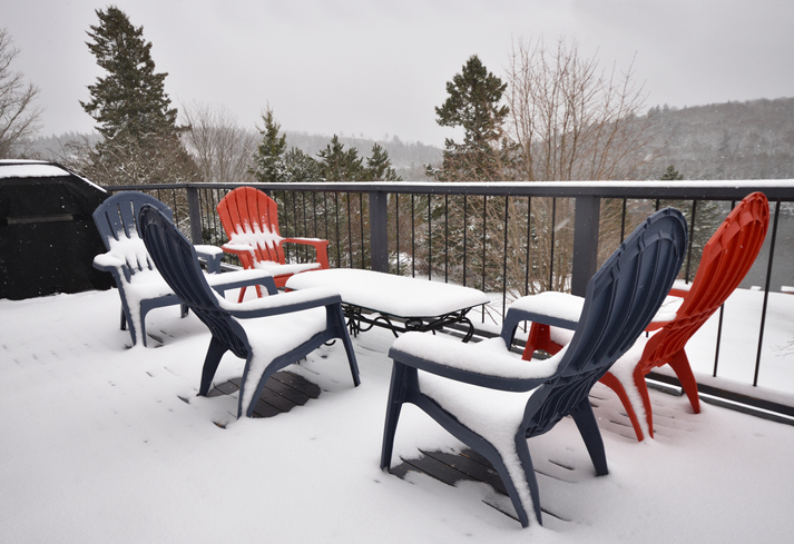 Deep snow covering a table and chairs on a vinyl deck