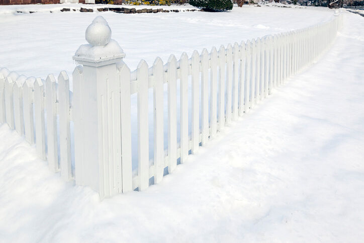 White vinyl fence half buried in snow